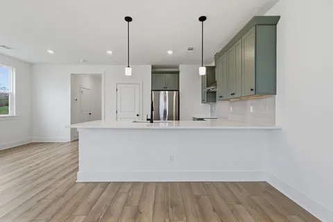 a view of a kitchen with wooden floor and a sink
