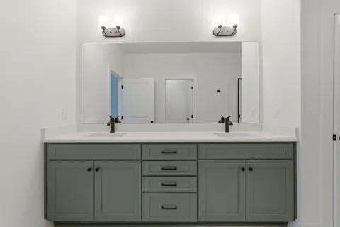 a bathroom with double sink and a mirror