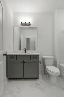 a bathroom with a toilet sink and mirror