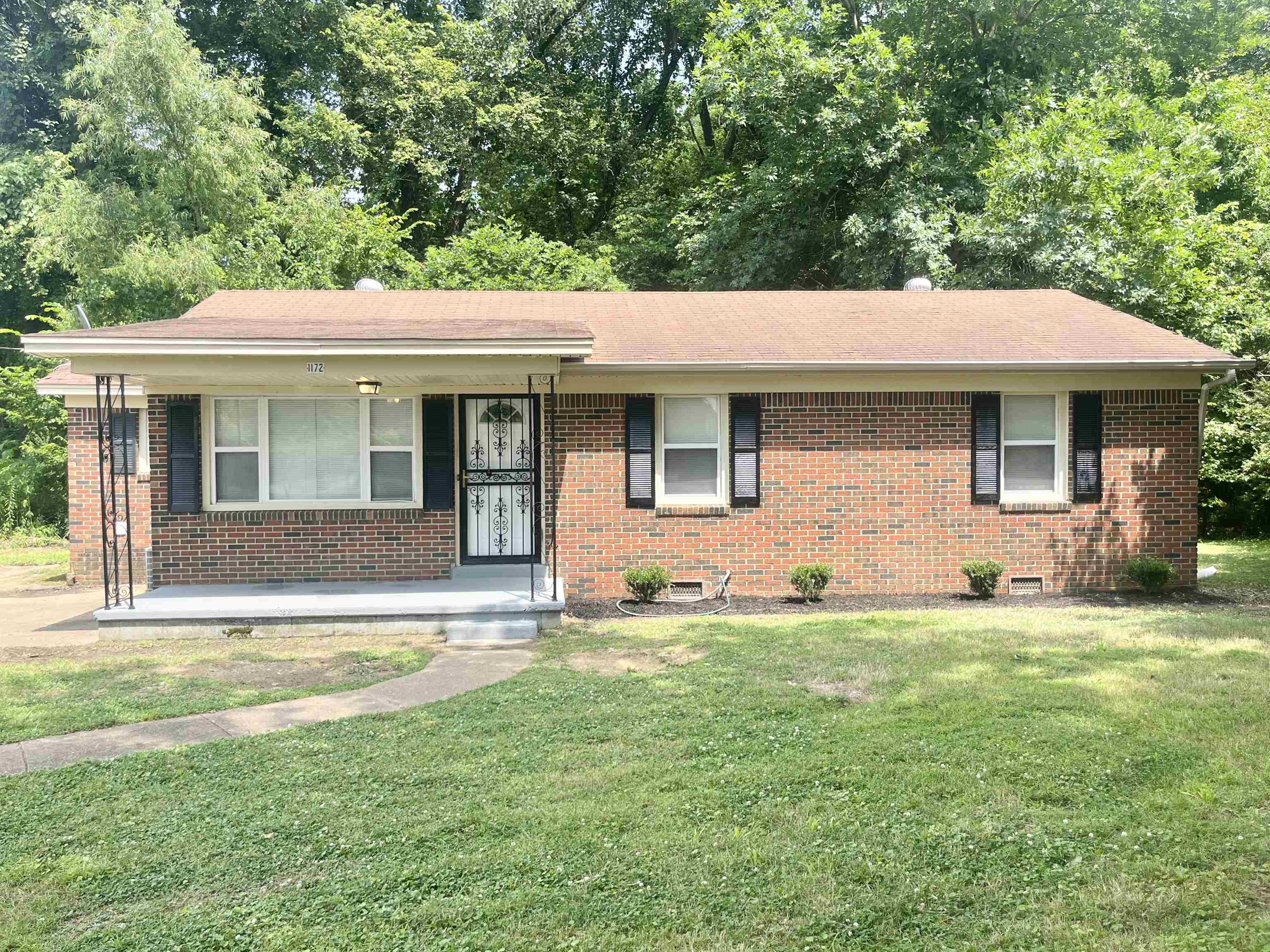 1172 Tabernacle Road Covington, TN 38019 - Photo 1 of 13 a front view of a house with a garden