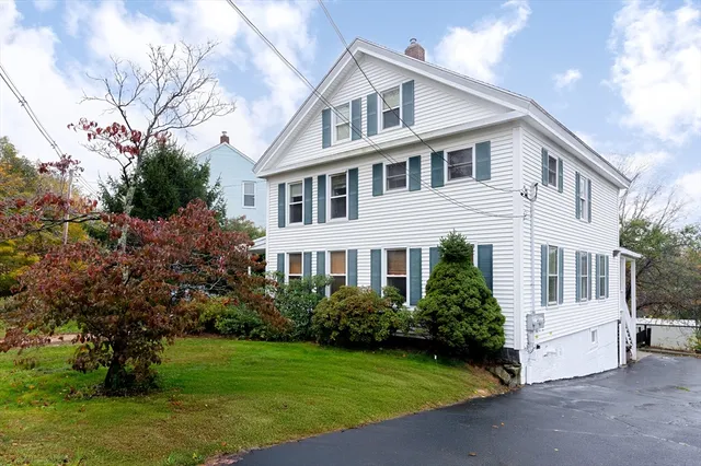 a view of a white house with a yard and plants