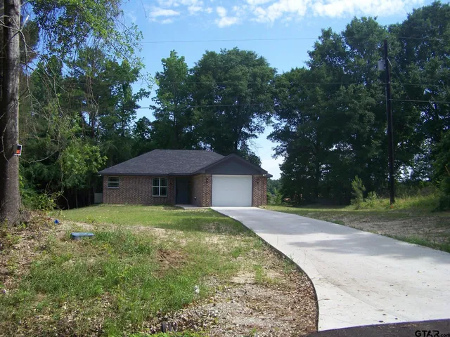 a front view of a house with yard and green space