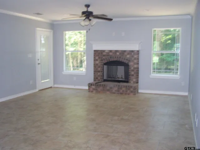 a view of empty room with windows and fireplace