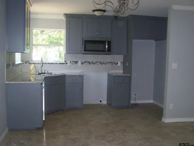 a kitchen with a sink cabinets and a window