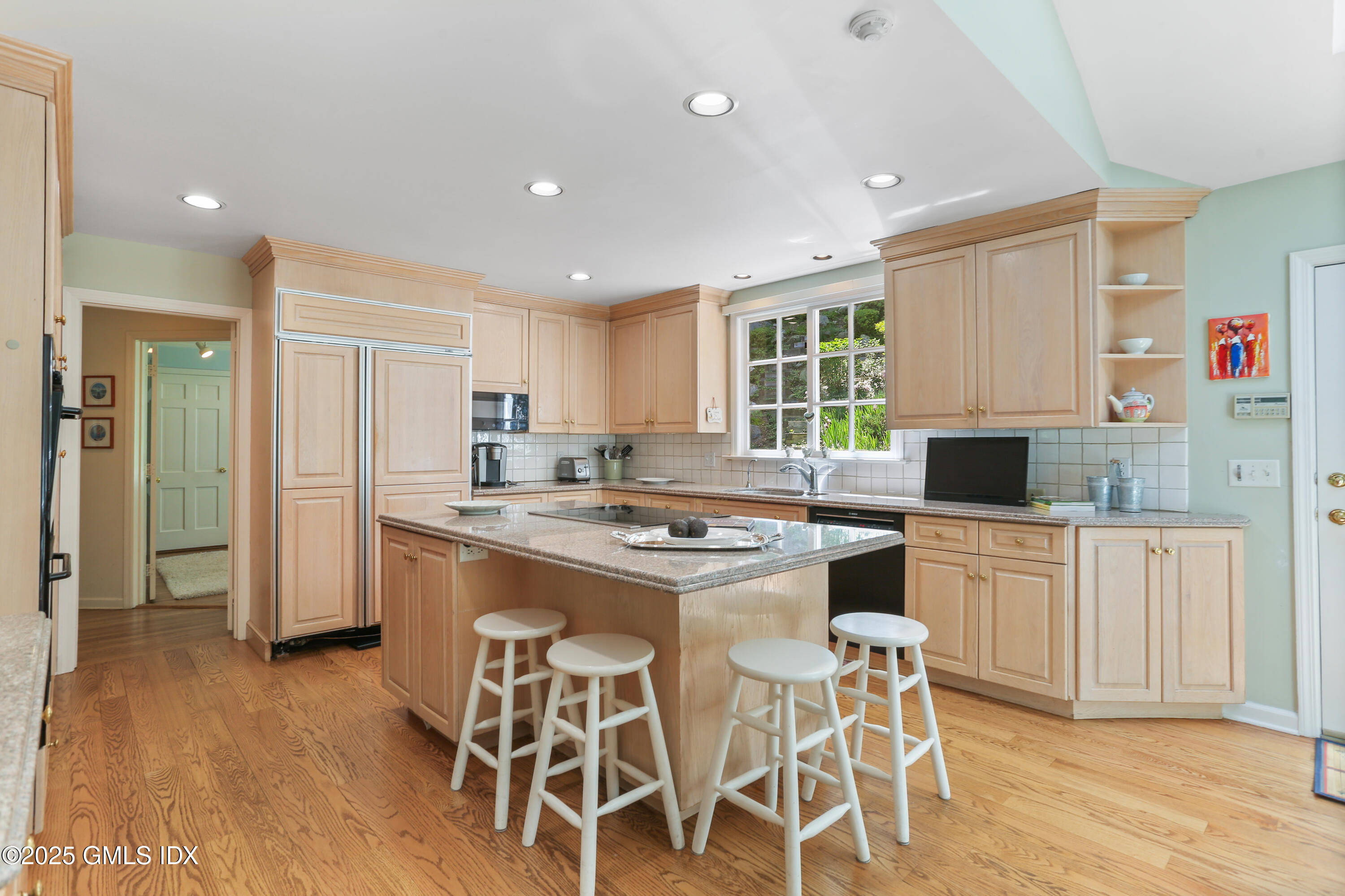 36 Horseshoe Road Cos Cob, CT 06807 - Photo 12 of 39 a kitchen with stainless steel appliances granite countertop a stove top oven a refrigerator a sink and a dining table with wooden floor