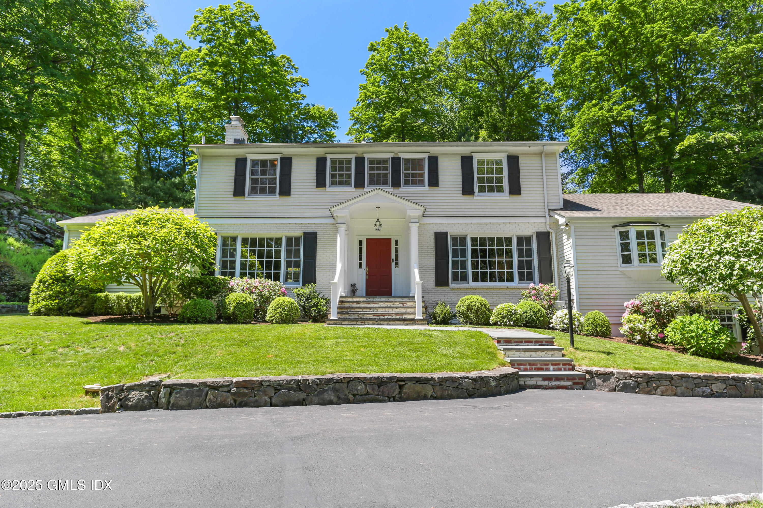 36 Horseshoe Road Cos Cob, CT 06807 - Photo 2 of 39 a front view of a house with a garden and yard