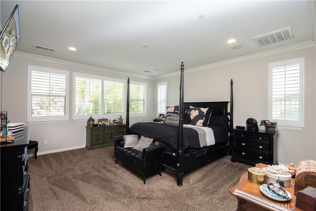 11950 Flicker Cove Corona, CA 92883 - Photo 11 of 28 a spacious bedroom with a bed and window