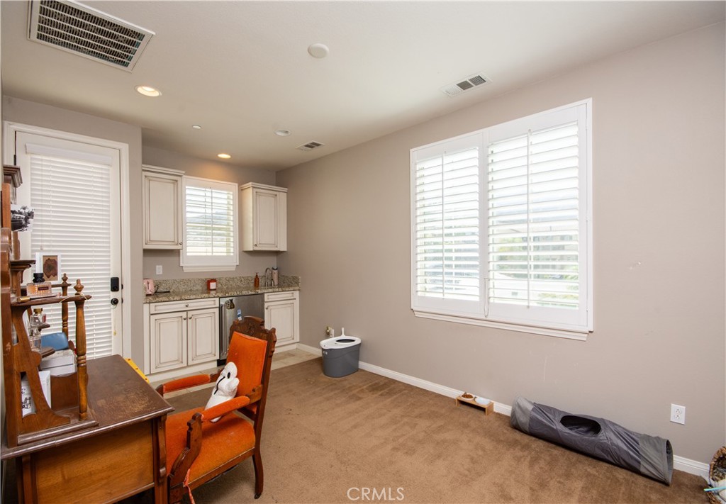 11950 Flicker Cove Corona, CA 92883 - Photo 14 of 28 a kitchen with a dining table chairs and refrigerator
