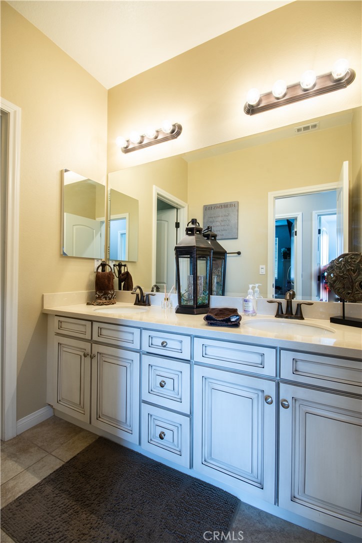 11950 Flicker Cove Corona, CA 92883 - Photo 15 of 28 a spacious bathroom with a double vanity sink and a mirror