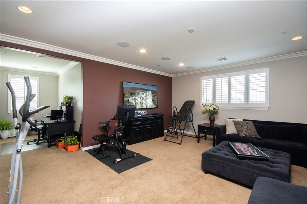 11950 Flicker Cove Corona, CA 92883 - Photo 17 of 28 a living room with furniture gym equipment and a window