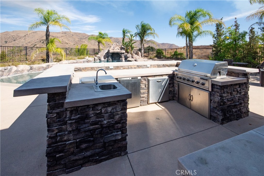 11950 Flicker Cove Corona, CA 92883 - Photo 24 of 28 a kitchen with a stove cabinets and a fireplace