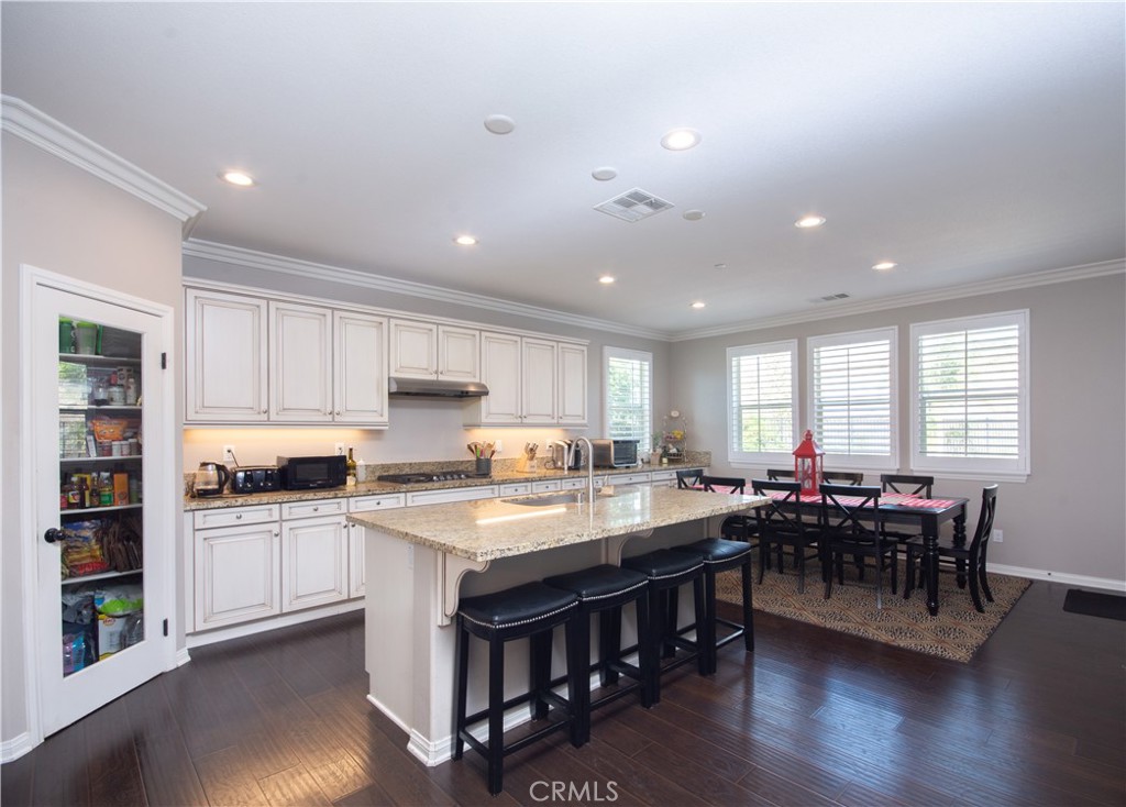 11950 Flicker Cove Corona, CA 92883 - Photo 4 of 28 a kitchen with stainless steel appliances granite countertop a stove and a dining table