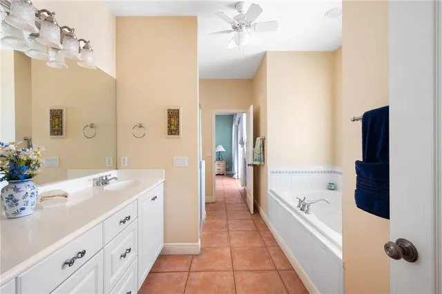 a spacious bathroom with a tub sink and mirror