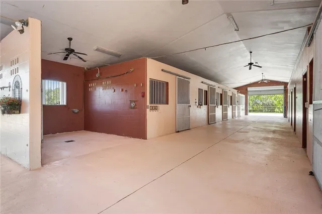 a view of an empty room with a window and kitchen view