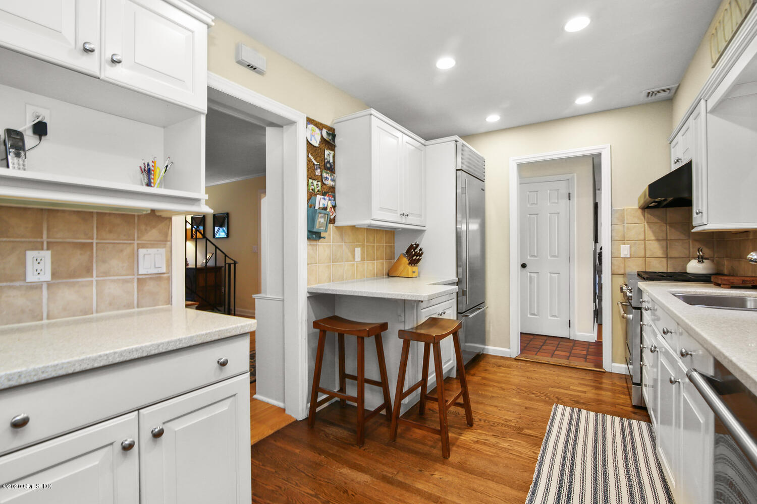 16 Ridge Road Cos Cob, CT 06807 - Photo 10 of 34 a kitchen with a table chairs refrigerator and cabinets