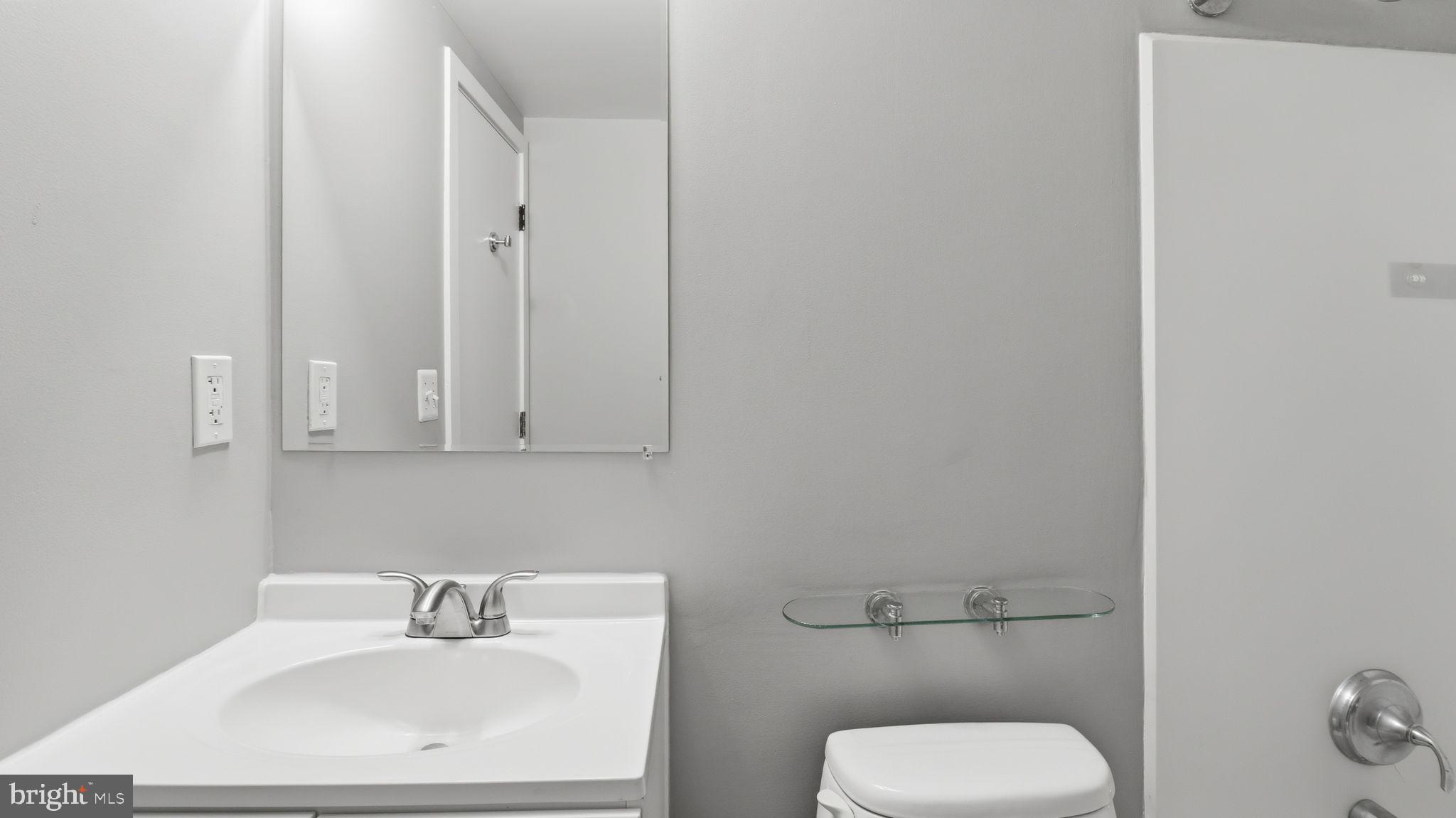 2317 16th Street Southeast, Unit 102 Washington, DC 20020 - Photo 23 of 23 a bathroom with a toilet sink and mirror