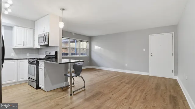a kitchen with a table chairs refrigerator and cabinets