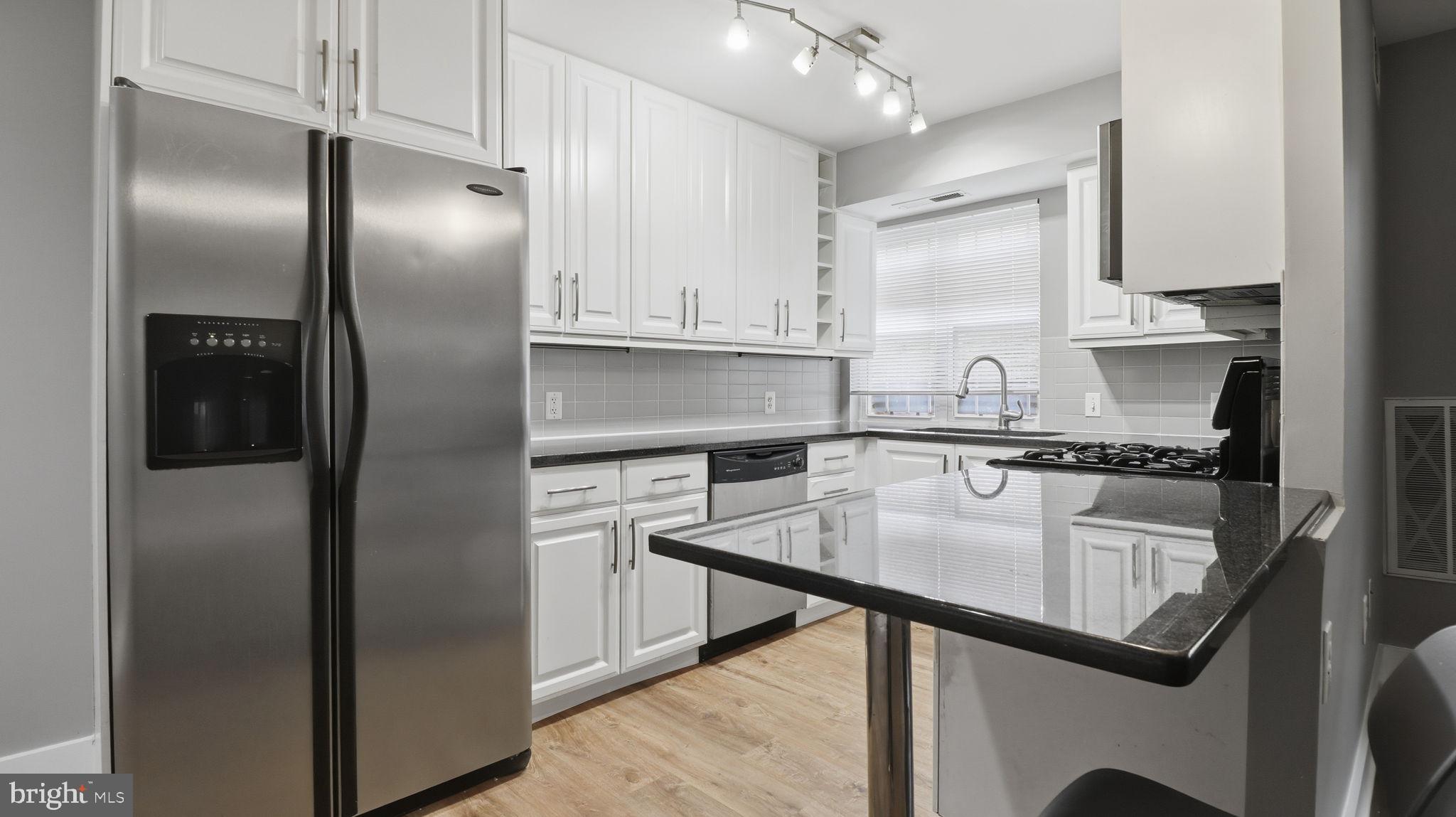 2317 16th Street Southeast, Unit 102 Washington, DC 20020 - Photo 6 of 23 a kitchen with kitchen island a counter top space cabinets and stainless steel appliances