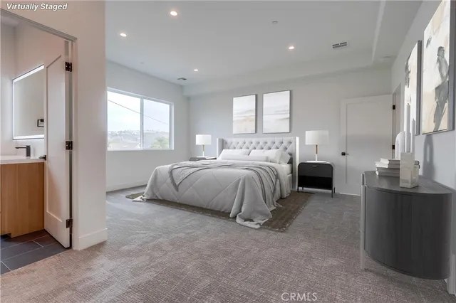 a spacious bedroom with a bed and a refrigerator