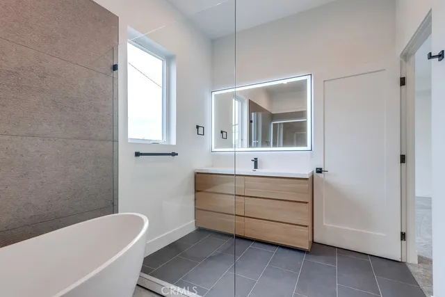 a bathroom with a tub sink and mirror