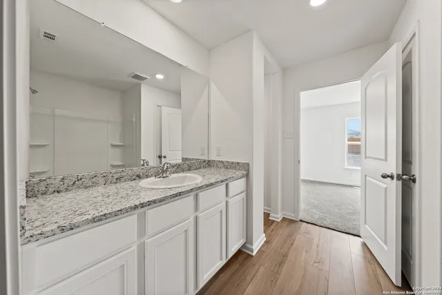 a bathroom with a granite countertop sink and a mirror