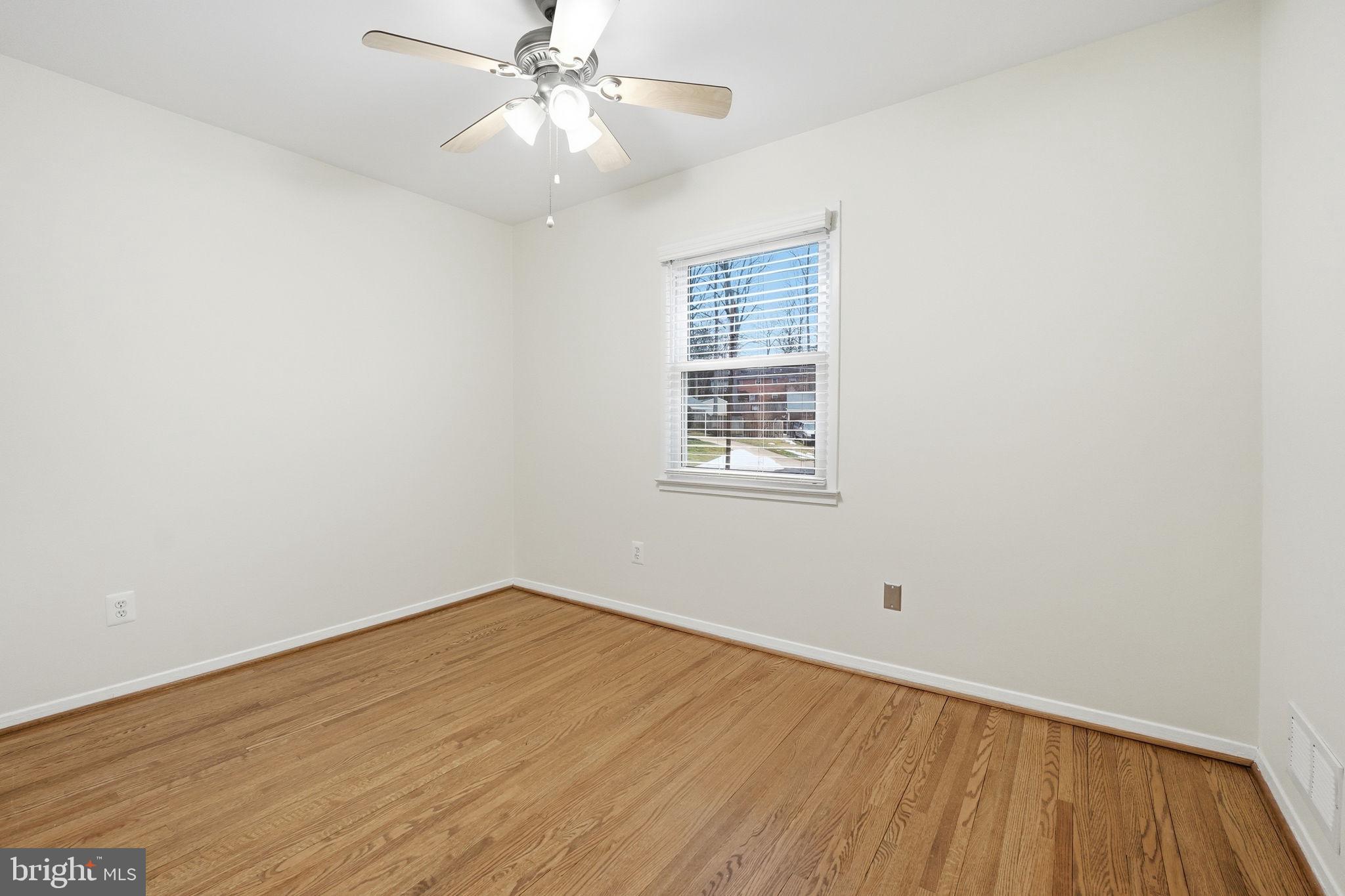 5718 Anola Court Springfield, VA 22151 - Photo 25 of 45 an empty room with wooden floor chandelier fan and windows