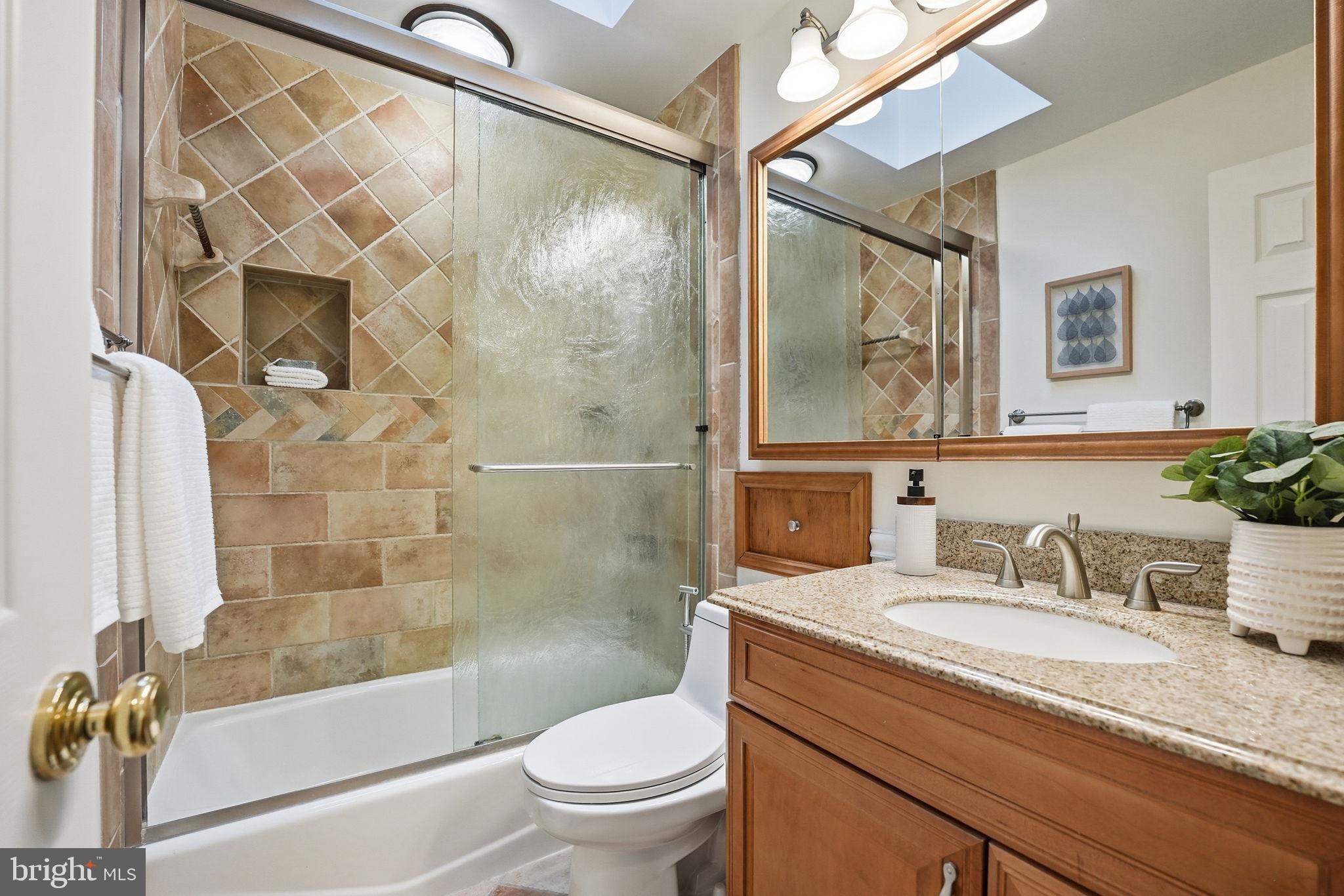 5718 Anola Court Springfield, VA 22151 - Photo 29 of 45 a bathroom with a granite countertop sink toilet and shower