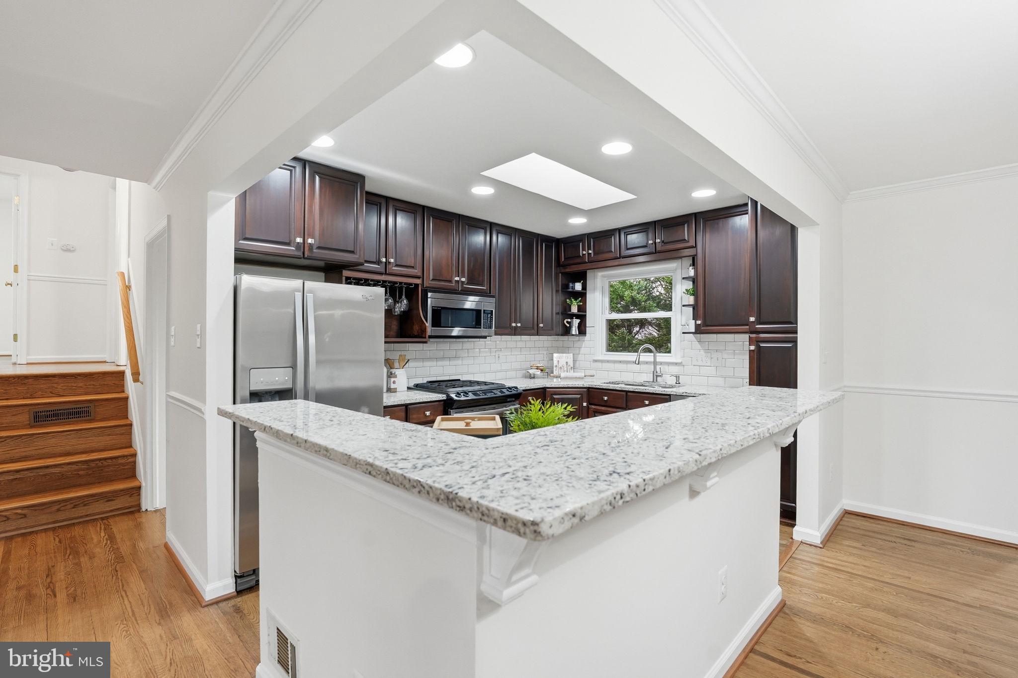 5718 Anola Court Springfield, VA 22151 - Photo 9 of 45 a kitchen with stainless steel appliances granite countertop a sink stove and refrigerator