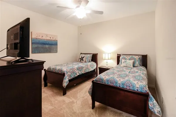 a bedroom with two beds and a flat screen tv