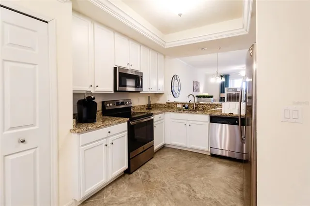 a kitchen with white cabinets and appliances