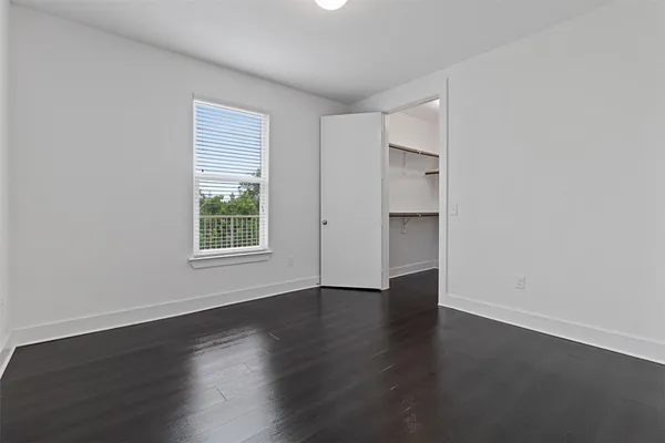 an empty room with wooden floor and window