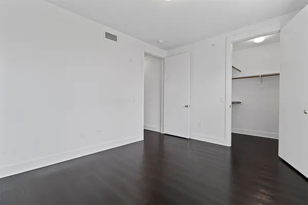 a view of an empty room with wooden floor