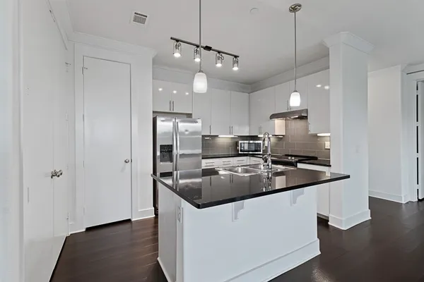 a kitchen with stainless steel appliances granite countertop a sink a stove and a refrigerator