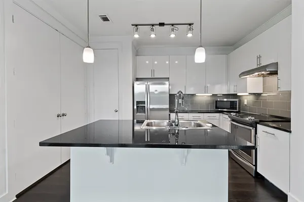 a kitchen with stainless steel appliances granite countertop a sink a stove and a refrigerator