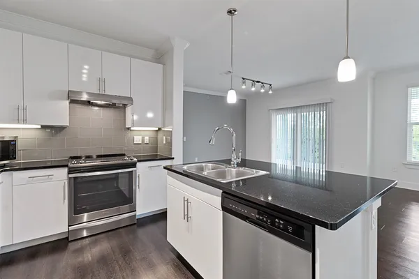 a kitchen that has a sink a stove and a wooden floors