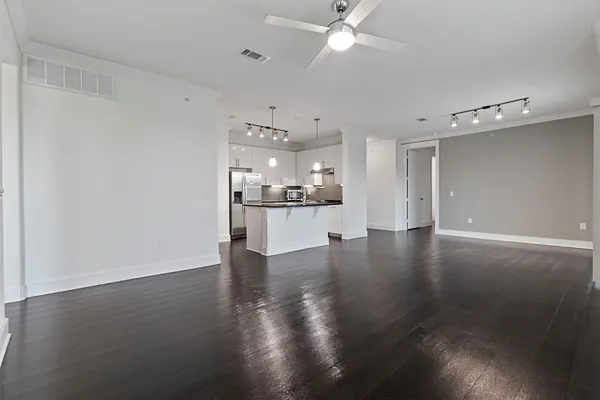 a view of a kitchen with a fridge and wooden floor