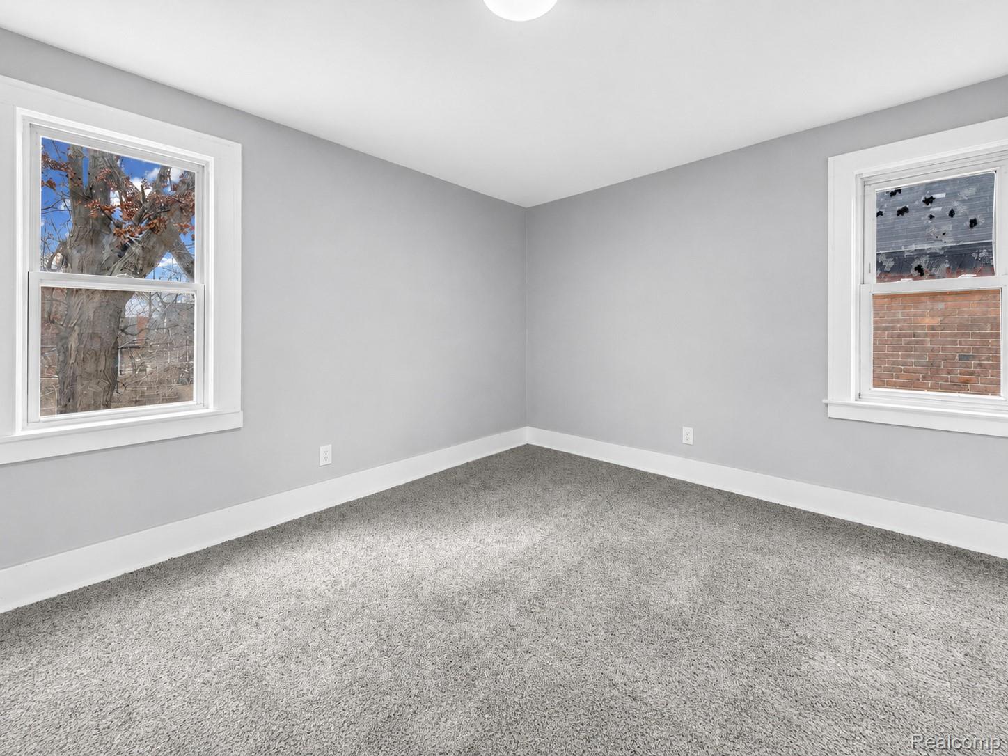 9175 Devonshire Road Detroit, MI 48224 - Photo 17 of 23 Room featuring light gray wall paint, gray carpeting, white trim, and a ceiling-mounted light fixture