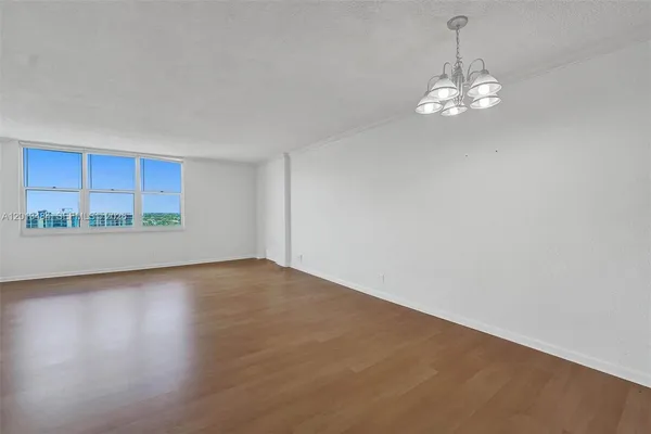 an empty room with wooden floor and window
