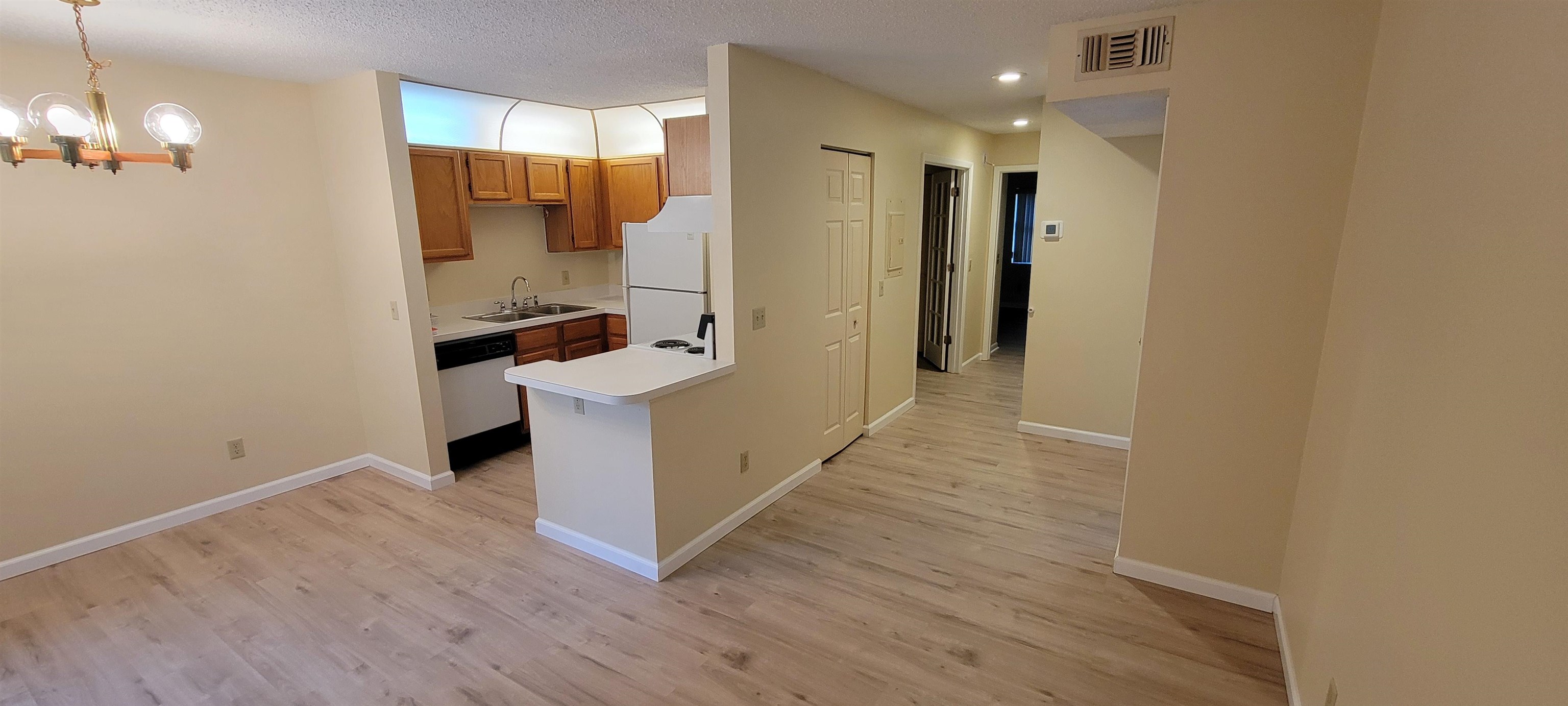 5 Catalonia Court St. Augustine, FL 32086 - Photo 9 of 30 Kitchen with wood finish cabinets, light countertops, suspended lighting, freestanding refrigerator, and light wood-type flooring