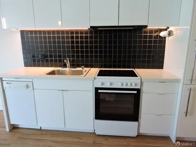 a kitchen with a stove and white cabinets