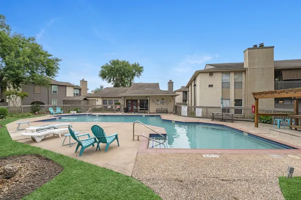 a view of a house with pool lawn chairs and a fire pit