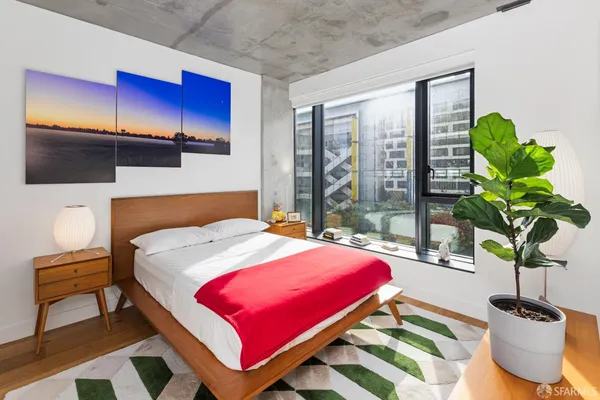 a bedroom with a bed and a large window with the outer view