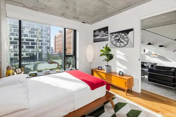 a bedroom with a bed and a lamp with the dresser