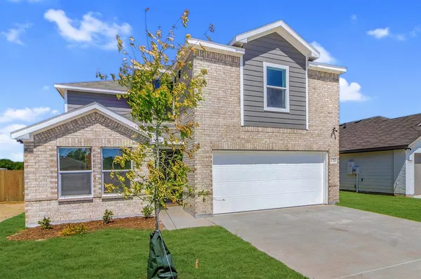 a front view of a house with a garden and yard