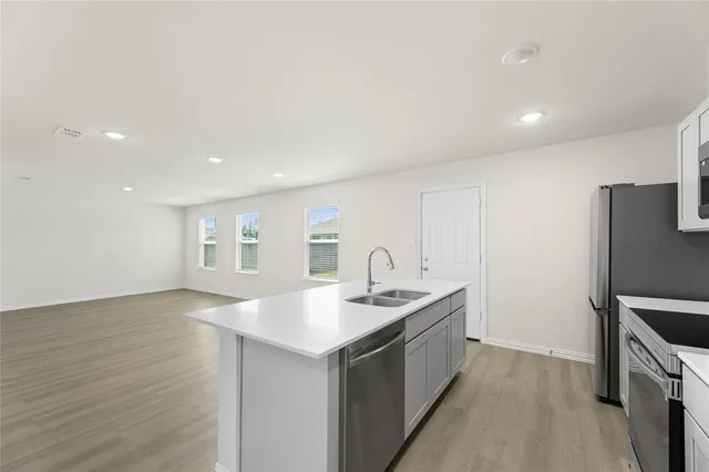 a kitchen with a sink cabinets and stainless steel appliances