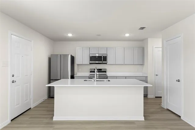a kitchen with stainless steel appliances granite countertop a refrigerator sink and microwave