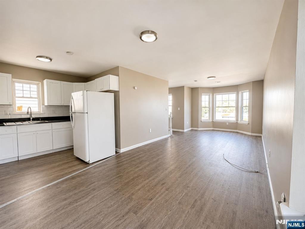 242 Rosa Parks Boulevard Paterson, NJ 07501 - Photo 1 of 6 a view of a kitchen with wooden floor and electronic appliances