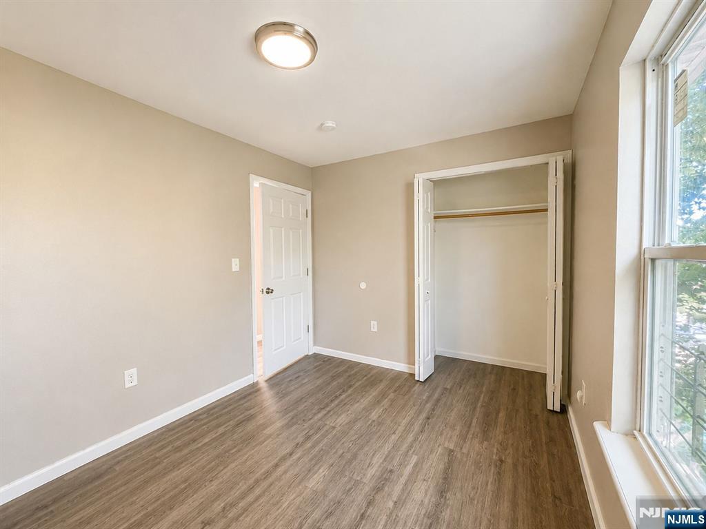 242 Rosa Parks Boulevard Paterson, NJ 07501 - Photo 2 of 6 an empty room with wooden floor and windows