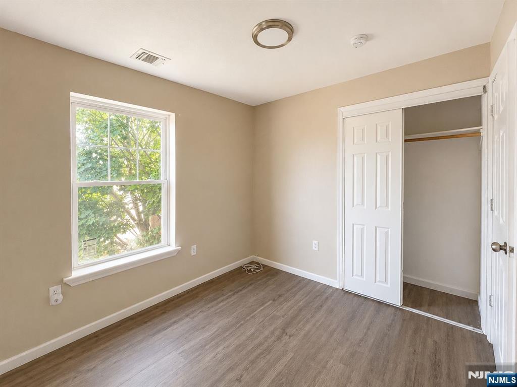242 Rosa Parks Boulevard Paterson, NJ 07501 - Photo 3 of 6 a view of an empty room with wooden floor and a window