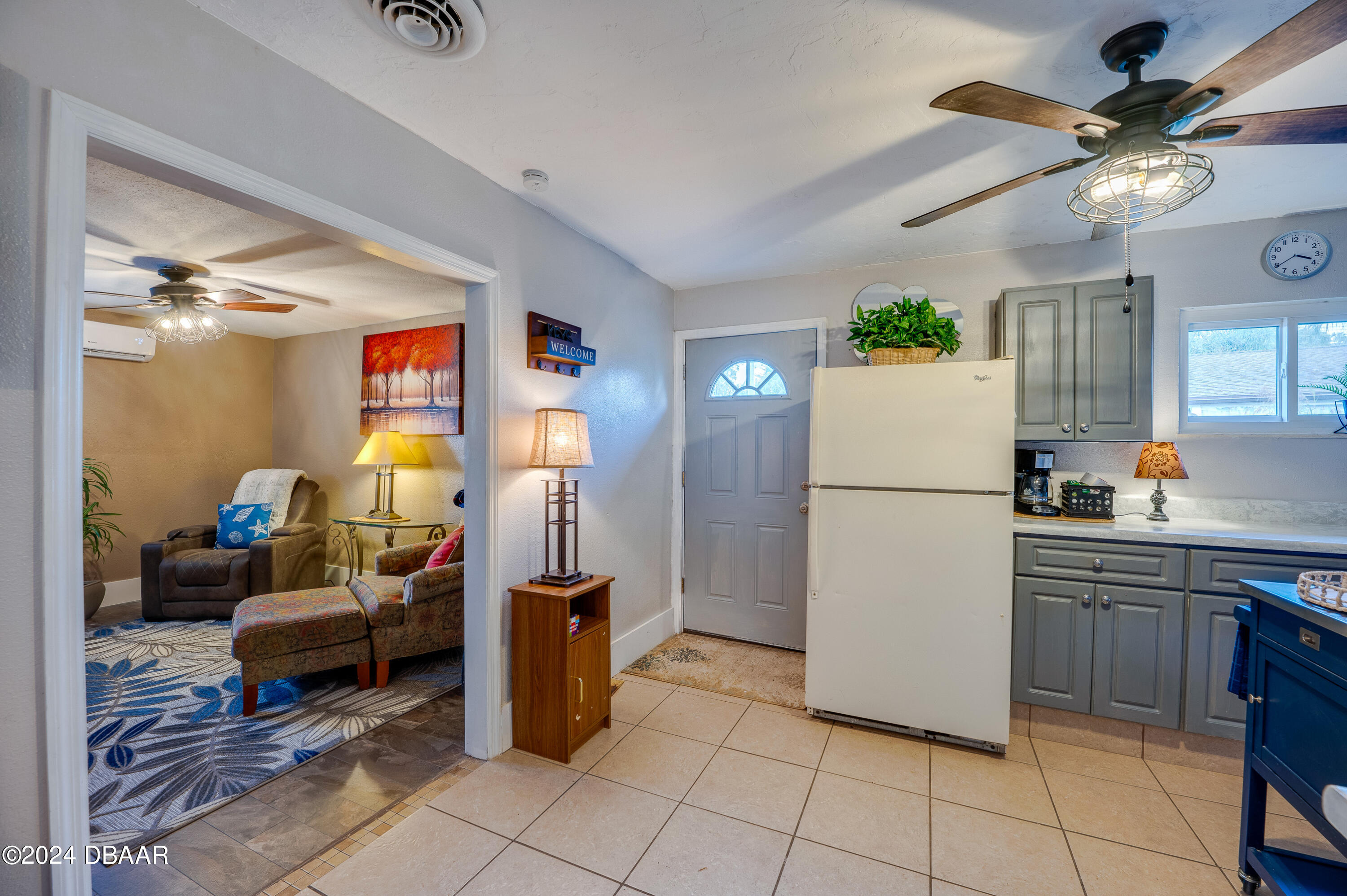 4850 Spruce Creek Road Port Orange, FL 32127 - Photo 18 of 27 a kitchen with a refrigerator a microwave oven a sink and a dining table